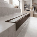 Solid Brass Stair Nosing 71mm Tread Square Front Slimline in Antique Bronze finish with Polar Grey Smooth Textured insert fitted on a retail store staircase with polished concrete treads
