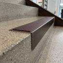 Solid Brass Stair Nosing 71mm Tread Square Front Slimline in Antique Bronze finish with Regency Castellated insert fitted on a retail store staircase with polished concrete treads