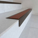 Solid Brass Stair Nosing 71mm Tread Square Front Slimline in Antique Bronze finish with Rustic Castellated insert fitted on a modern office reception staircase with porcelain tile treads