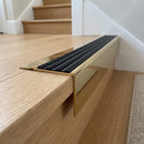 Solid Brass Stair Nosing 71mm Tread Square Front Slimline in Polished Brass finish with Black Castellated insert fitted on a residential oak staircase