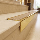 Solid Brass Stair Nosing 71mm Tread Square Front Slimline in Polished Brass finish with Fawn Castellated insert fitted on a hotel lobby staircase with cream marble treads
