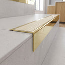 Solid Brass Stair Nosing 71mm Tread Square Front Slimline in Polished Brass finish with Ivory Castellated insert fitted on a modern office reception staircase with porcelain tile treads