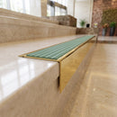 Solid Brass Stair Nosing 71mm Tread Square Front Slimline in Polished Brass finish with Jade Castellated insert fitted on a hotel lobby staircase with cream marble treads