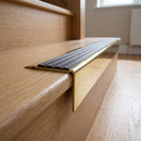 Solid Brass Stair Nosing 71mm Tread Square Front Slimline in Polished Brass finish with Peat Castellated insert fitted on a residential oak staircase