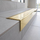 Solid Brass Stair Nosing 71mm Tread Square Front Slimline in Polished Brass finish with Polished Brass insert fitted on a modern office reception staircase with porcelain tile treads