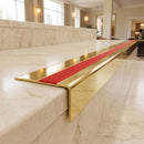 Solid Brass Stair Nosing 71mm Tread Square Front Slimline in Polished Brass finish with Poppy Castellated insert fitted on a hotel lobby staircase with cream marble treads