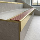 Solid Brass Stair Nosing 71mm Tread Square Front Slimline in Polished Brass finish with Rustic Castellated insert fitted on a modern office reception staircase with porcelain tile treads