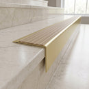 Solid Brass Stair Nosing 71mm Tread Square Front Slimline in Satin Brass finish with Fawn Castellated insert fitted on a hotel lobby staircase with cream marble treads