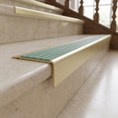 Solid Brass Stair Nosing 71mm Tread Square Front Slimline in Satin Brass finish with Jade Castellated insert fitted on a hotel lobby staircase with cream marble treads