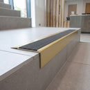 Solid Brass Stair Nosing 71mm Tread Square Front Slimline in Satin Brass finish with Nimbus Castellated insert fitted on a modern office reception staircase with porcelain tile treads