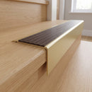 Solid Brass Stair Nosing 71mm Tread Square Front Slimline in Satin Brass finish with Peat Castellated insert fitted on a residential oak staircase
