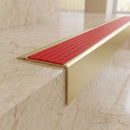 Solid Brass Stair Nosing 71mm Tread Square Front Slimline in Satin Brass finish with Poppy Castellated insert fitted on a hotel lobby staircase with cream marble treads