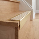 Solid Brass Stair Nosing 71mm Tread Square Front Slimline in Satin Brass finish with Porth Stone Castellated insert fitted on a residential oak staircase