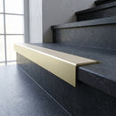 Solid Brass Stair Nosing 71mm Tread Square Front Slimline in Satin Brass finish with Porth Stone Smooth Textured insert fitted on a public building staircase with dark stone treads