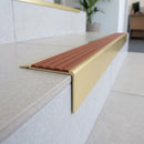Solid Brass Stair Nosing 71mm Tread Square Front Slimline in Satin Brass finish with Rustic Castellated insert fitted on a modern office reception staircase with porcelain tile treads