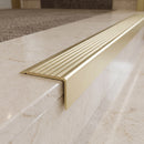Solid Brass Stair Nosing 71mm Tread Square Front Slimline in Satin Brass finish with Satin Brass insert fitted on a hotel lobby staircase with cream marble treads