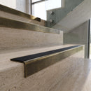 Antique Brass finish - solid brass stair nosing with black carborundum insert fitted on travertine steps