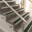 Raked back nosings with spruce green ribbed inserts on mottled stone steps between stainless handrails