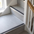 Square edge aluminium stair nosing with a dark charcoal Mor Grip insert in mill finish finish fitted on a domestic staircase finished in light grey vinyl