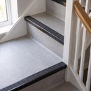 Square edge aluminium stair nosing with a dark charcoal Mor Grip insert in satin black finish fitted on a domestic staircase finished in light grey vinyl
