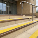 Satin bronze 56mm square aluminium stair nosing with brimstone (safety yellow) exterior grip insert on buff concrete entrance steps outside a health centre