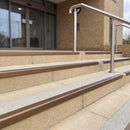 Satin bronze 56mm square aluminium stair nosing with everest (light grey) exterior grip insert on buff concrete entrance steps outside a health centre