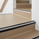 Square aluminium stair nosing with black insert in mill finish finish fitted on a shop entrance stair with beige lino