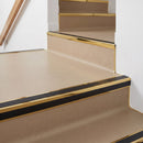 Square aluminium stair nosing with black insert in mirrorflect gold finish fitted on a shop entrance stair with beige lino