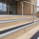Mill finish 56mm square aluminium stair nosing with coal (black) exterior grip insert on buff concrete entrance steps outside a health centre