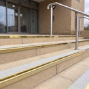 Mirror polished gold 56mm square aluminium stair nosing with everest (light grey) exterior grip insert on buff concrete entrance steps outside a health centre