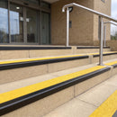 Satin black 56mm square aluminium stair nosing with brimstone (safety yellow) exterior grip insert on buff concrete entrance steps outside a health centre