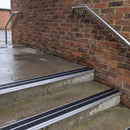 Square edge aluminium stair nosing with black gritted exterior grip insert in mill finish finish fitted on covered external concrete steps