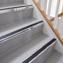 Square aluminium stair nosing with black insert in bright polished finish fitted on a home staircase with grey vinyl