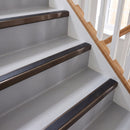 Square aluminium stair nosing with black insert in dark bronze finish fitted on a home staircase with grey vinyl