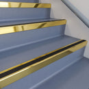 Square DDA aluminium stair nosing with black insert in mirrorflect gold finish fitted on a public building stair with blue-grey safety vinyl