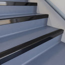 Square DDA aluminium stair nosing with black insert in satin black finish fitted on a public building stair with blue-grey safety vinyl