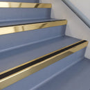 Square DDA aluminium stair nosing with black insert in satin gold finish fitted on a public building stair with blue-grey safety vinyl