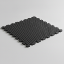 Black interlocking rubber stable mat with bubble-top texture, studio product shot showing jigsaw edges