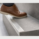 Close-up of the 30mm ribbed stainless steel tread wrapping the edge of a grey tiled step