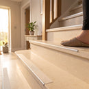 Stainless steel stair nosing with clear R10 textured tread fitted to pale limestone steps in a home hallway