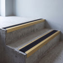 Gold anodised 46x30mm stair nosing with black anti-slip rubber insert fitted to bare concrete stairs