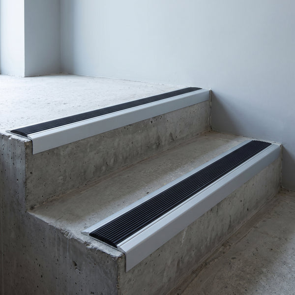 Silver anodised 46x30mm stair nosing with black anti-slip rubber insert fitted to bare concrete stairs