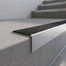 Slimline 59x30mm square back aluminium stair nosing with a black Olympic Grip aluminium oxide insert, on a satin aluminium bar, fitted along the front edge of a concrete step