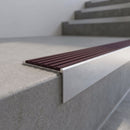 Slimline 59x30mm square back aluminium stair nosing with a deep claret ribbed PVC insert, on a satin aluminium bar, fitted along the front edge of a concrete step