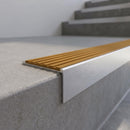 Slimline 59x30mm square back aluminium stair nosing with a golden amber ribbed PVC insert, on a satin aluminium bar, fitted along the front edge of a concrete step