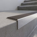 Slimline 59x30mm square back aluminium stair nosing with a granite taupe-brown ribbed PVC insert, on a satin aluminium bar, fitted along the front edge of a concrete step
