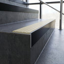 Slimline 59x30mm square back aluminium stair nosing with an ivory cream ribbed PVC insert, on a black anodised bar, fitted along the front edge of a concrete step