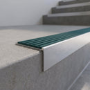Slimline 59x30mm square back aluminium stair nosing with a jade teal-green ribbed PVC insert, on a satin aluminium bar, fitted along the front edge of a concrete step