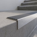 Slimline 59x30mm square back aluminium stair nosing with a light grey ribbed PVC insert, on a satin aluminium bar, fitted along the front edge of a concrete step