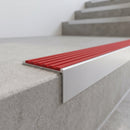 Slimline 59x30mm square back aluminium stair nosing with a poppy red ribbed PVC insert, on a satin aluminium bar, fitted along the front edge of a concrete step